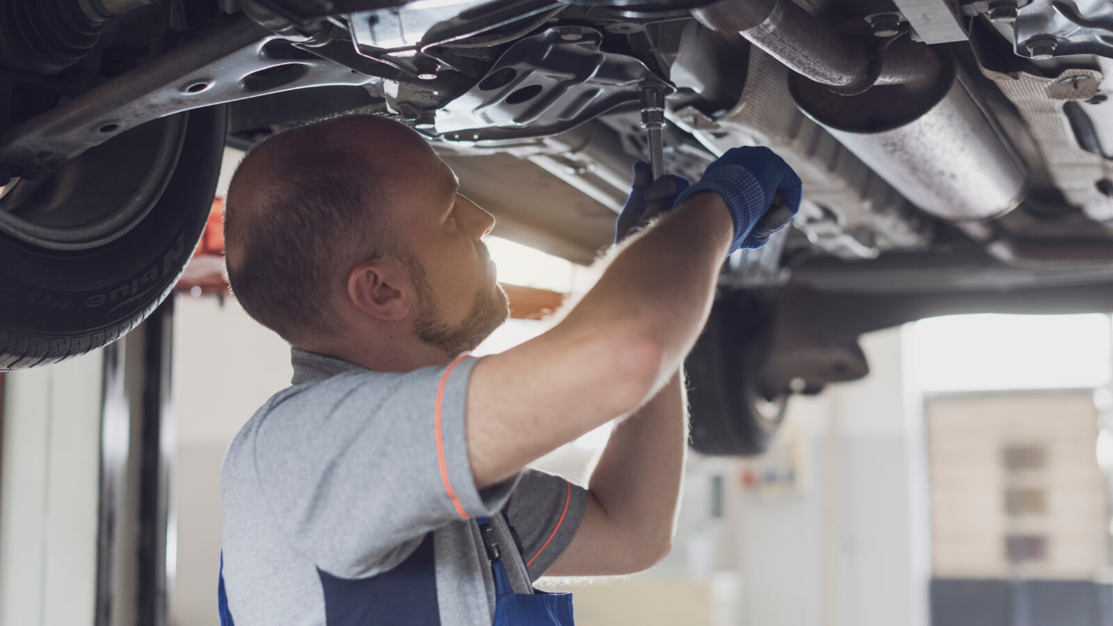 Man werkt aan onderkant auto